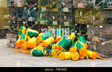 Le trappole a base di aragosta e boe per identificare i proprietari sono impilati nella parte superiore di ogni altro pronta per essere distribuita nell'oceano nel Maine. Foto Stock