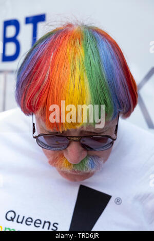 Un Irish American uomo che tinto i suoi capelli e baffi con i colori della bandiera LGBT al 2019 Queens Pride Parade in Jackson Heights, Queens, NYC. Foto Stock