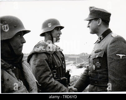 Waffen SS Sturmbannfuhrer principali Franz Hack si congratula con due dei suoi uomini vestiti in inverno Eskimo 1944 sul Fronte Orientale Foto Stock