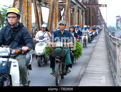 Il traffico di persone sui binari della ferrovia che conduce su lunghe Bien Bridge, costruito all inizio del secolo XX è stato progettato da Gustave Eiffel in Hanoi Foto Stock