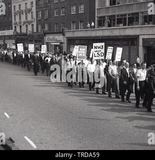 1964, storici e impressionanti postini della Royal Mail, membri dell'Unione dei lavoratori postali (UPM) che camminano in una processione attraverso il centro di Londra tenendo cartelli con messaggi di protesta e chiedendo un accordo equo per i lavoratori postali. A quel tempo, c'era una particolare angoscia nei confronti di Ernest Bevin, l'ex leader del grande sindacato, l'Unione dei Trasporti e dei lavoratori generali (TGWU). Foto Stock