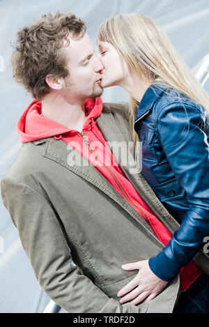 Ritratto di una giovane coppia abbracciando e baciando ogni altro all'aperto Foto Stock
