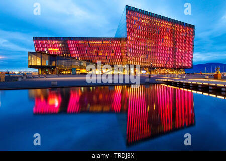 Illuminata Harpa concert hall con segni distintivi di vetro colorato facace di sera, l'Islanda, Reykjavik Foto Stock