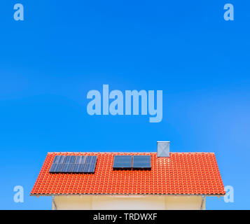 Dettaglio della casa residenziale tetto con pannelli solari contro il cielo blu Foto Stock