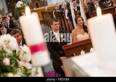 Coppia di sposi seduto accanto a ogni altra davanti all altare al matrimonio chiesa Foto Stock