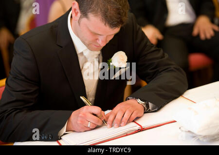 Lo sposo firma nel matrimonio prenota Foto Stock