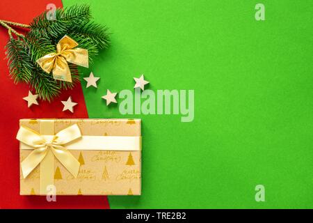 Decorazione di Natale sfondo in rosso e verde con abete rosso ramoscello, stelle, nastro e regalo Foto Stock