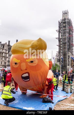 I manifestanti che gonfiano un enorme pallone aerostatico di Donald Trump al di fuori del Parlamento per manifestare contro la visita di Stato del Presidente degli Stati Uniti in corso a Londra, nel Regno Unito. I manifestanti stanno pianificando una grande manifestazione sperando di distruggere i piani del Presidente Foto Stock