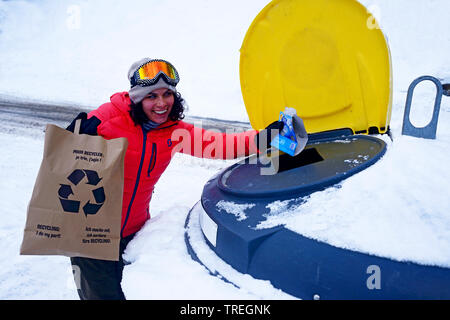 Donna gettare i rifiuti nel bidone dei rifiuti, raccolta differenziata dei rifiuti, Francia, Savoie, Sainte-Foy-Tarentaise Foto Stock