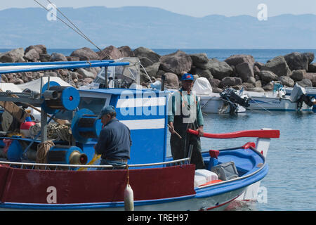 Due pescatori su una barca da pesca in porto, Grecia LESBO Foto Stock