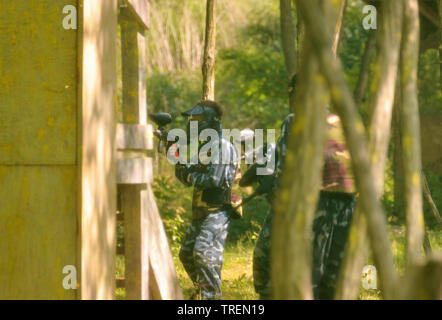 Battaglia di paintball. Lo scontro tra squadre avversarie è in pieno svolgimento: tutti i giocatori punto le loro armi presso i propri avversari per sparare proiettili di vernice. Foto Stock