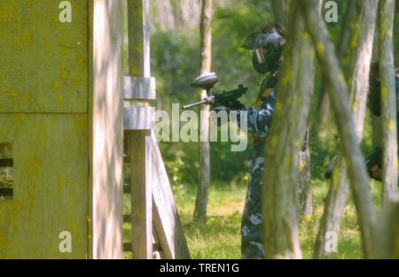 Battaglia di paintball. Lo scontro tra squadre avversarie è in pieno svolgimento: tutti i giocatori punto le loro armi presso i propri avversari per sparare proiettili di vernice. Foto Stock