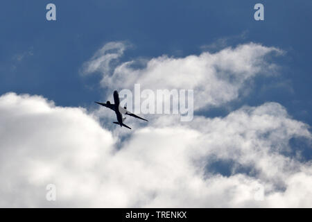 Aeroplano che vola nel cielo. Silhouette di un aereo di passeggero decollare su sfondo di nuvole di tempesta Foto Stock