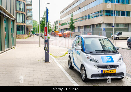 Amsterdam, Paesi Bassi - 12 Giugno 2016: Auto2Go auto elettrica essendo caricato. Car2go è carsharing servizio disponibile in Europa e Nord America. Foto Stock