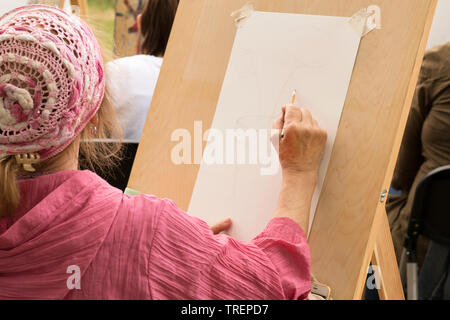 Mosca - Giugno 1, 2019: Senior donna richiama lo schizzo a matita sul cavalletto a scuola d'arte. Argomento per la creatività, hobby per i pensionati, programmi sociali f Foto Stock