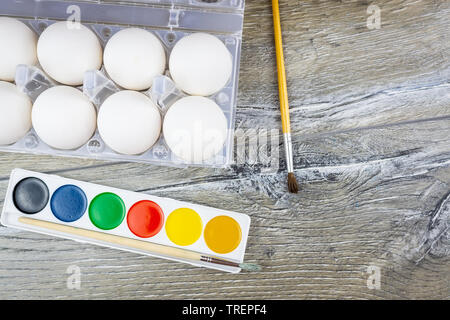 Le uova bianche, vernici, nappe, preparazione per la colorazione per la Pasqua. Foto Stock