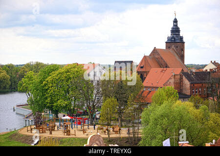 Havelberg, Sassonia Anhalt/ Germania 12 Maggio 2019: Cityscape di Havelberg al fiume Havel con la sua chiesa di San Lorenzo. Il parco giochi di fronte con la gente. Foto Stock