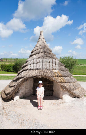 Esterno del ricreato il neolitico Età della pietra hut / stoneage capanne col tetto di paglia / tetti . Esposizione; Visitor Center Stonehenge / Stone henge. Amesbury, Wiltshire, Regno Unito (109) Foto Stock