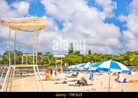 Ombrelloni e sedie bagnino sulla spiaggia sabbiosa Naminoue nella città di Naha nella Prefettura di Okinawa, in Giappone. Foto Stock