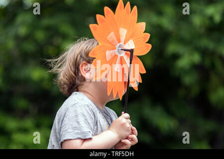 Un ragazzino in esecuzione con fiori artificiali nelle sue mani, outdoor sfocato motion shot Foto Stock