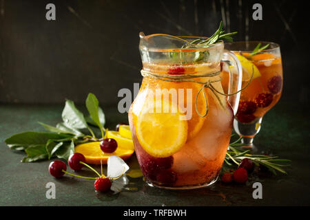 Fatti in casa vino rinfrescante sangria o punzone con frutti. La sangria cocktail con frutta fresca e bacche e rosmarino sul buio di una pietra o ardesia sfondo. Foto Stock
