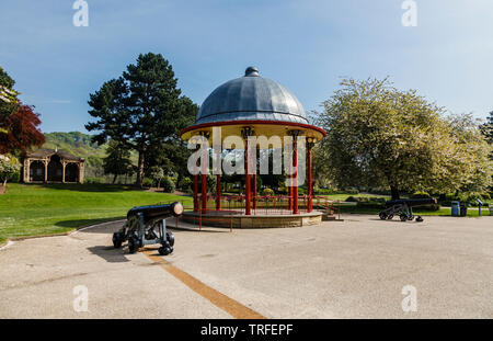 Due il Colonnello William Dundas cannoni da entrambi i lati del palco per spettacoli, con la statua di Sir Tito sale, Roberts Park, Saltaire, Bradford, West Yorkshire Foto Stock