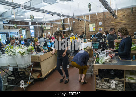 Gli amanti dello shopping al checkout contatori alla sempre occupato Park Slope Food Coop a Park Slope, Brooklyn, New Yortk. Foto Stock