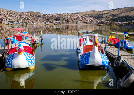 Animale-sagomato pedalò o barche a pedali a Puno porta sul lago Titicaca con la città di Puno in background, Perù Foto Stock