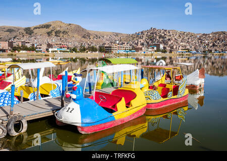 Animale-sagomato pedalò o barche a pedali a Puno porta sul lago Titicaca con la città di Puno in background, Perù Foto Stock