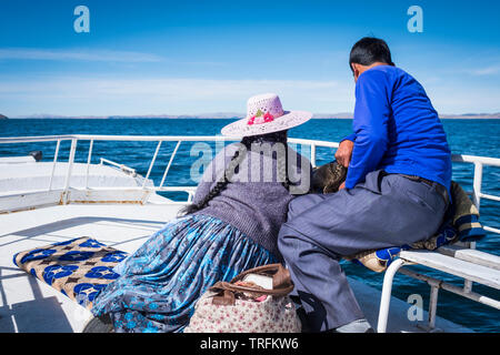 Locale giovane godendo la vista dal ponte superiore a bordo di una barca turistica tour del lago Titicaca Puno, Regione, Perù Foto Stock