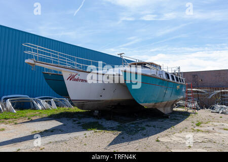 Benton Harbor, Michigan, Stati Uniti d'America - 4 Maggio 2019: il vecchio trimarano sotto restauro in un negozio Foto Stock