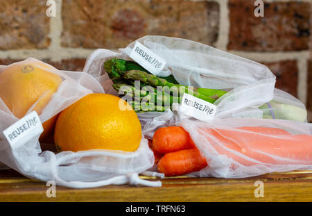 La frutta e la verdura riutilizzabili in borse di maglia, con il riutilizzo di me etichette, sul banco di cucina, autentica reale libero di plastica eco friendly shopping Foto Stock