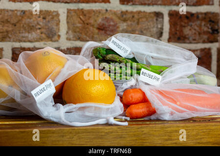 La frutta e la verdura riutilizzabili in borse di maglia, con il riutilizzo di me etichette, sul banco di cucina, autentica reale libero di plastica eco friendly shopping Foto Stock