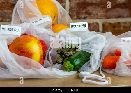 La frutta e la verdura riutilizzabili in borse di maglia, con il riutilizzo di me etichette, sul banco di cucina, autentica reale libero di plastica eco friendly shopping Foto Stock