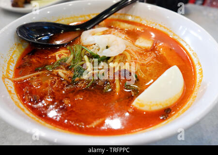 Curry Zuppa di gamberetti di pesce con latte di cocco e verdure Erbe piccanti di spezie nella ciotola / cibo malese a base di noodle soup Foto Stock