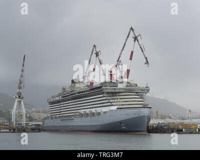 Genova Italia 19 Maggio 2019: nuova nave da crociera scarlet lady in costruzione attraccata ad una banchina di un cantiere con gru di grandi dimensioni Foto Stock