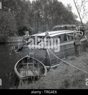 Degli anni Cinquanta, storico, gite in barca sul fiume Tamigi.....due coppie mature su una tavola di legno di una barca a motore barca 'Jolly giorni" costruito da F. B selvagge di Horning, ormeggiata fino al fianco di un argine nei pressi di Oxford, Inghilterra, Regno Unito. Foto Stock