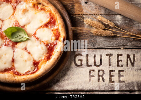 Un senza glutine pizza su di un legno rustico sfondo, close up Foto Stock