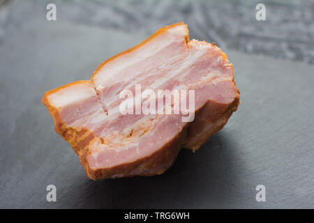 La pancetta affumicata, in casa di carne di maiale affumicata petto su sfondo scuro Foto Stock