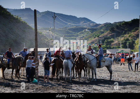 Tradizionale nastro horse racing al Benamargosa Romeria. Equitazione la concorrenza si svolge lungo il letto del fiume secco come parte del festival Foto Stock