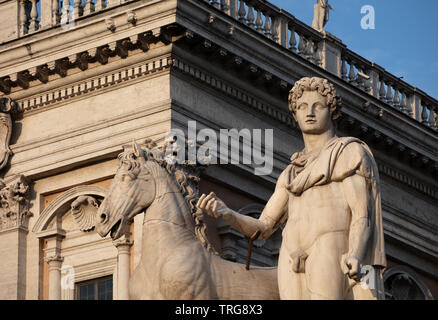 Una antica statua romana di uno dei Dioscuri (o di Castore e Polluce) nella parte superiore dei passi presso il Campidoglio in serata sole. Foto Stock