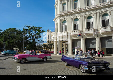 L'Avana, Cuba - 31 Gennaio 2018: due vecchi taxi cabriolet in piedi di fronte ad un albergo in Havana downtow, in attesa per i clienti Foto Stock