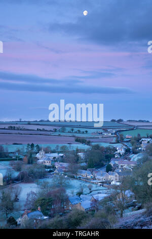 La calante gibbous moon over Poyntington su un gelido inverno mattina, Dorset, England, Regno Unito Foto Stock