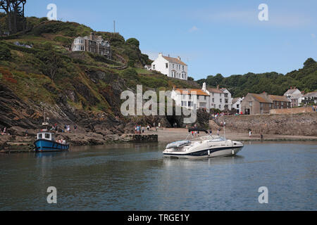 Il porto esterno di Polperro a bassa marea con un motoscafo in plastica di rovinare la vista Foto Stock