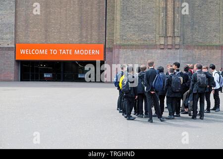 Un gruppo di ragazzi della scuola gli studenti studenti visitando la Tate Modern Art Gallery in piedi fuori dall'ingresso all'edificio in Londra England Regno Unito KATHY DEWITT Foto Stock