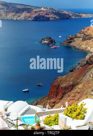 Catamarano e barche a vela su un oceano di calma nella caldera come visto da un alto luogo di Oia - Santorini, Grecia. Foto Stock