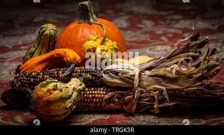 Zucche colorate e squash, Zucche e mais vitreo giacciono su una tabella durante l'autunno. Foto Stock