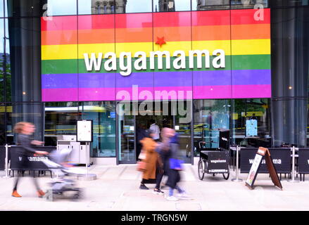 Esterno del Wagamama Restaurant in St Peter's Square, nel centro di Manchester, Regno Unito; le persone che camminano davanti sono sfocate a causa della bassa velocità dell'otturatore della fotocamera Foto Stock