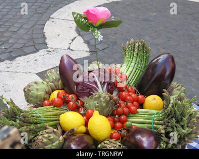 Display a colori dei prodotti di mercato freschi con un array di artistico di frutta e verdura; gli asparagi, melanzana, carciofi, limoni, cavolo e pomodori Foto Stock