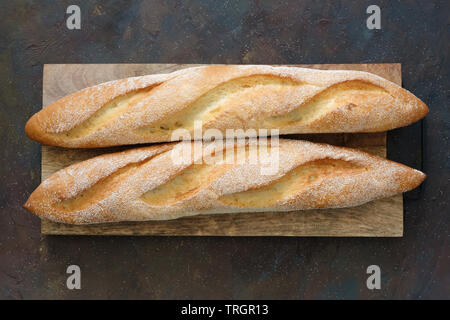 Due appena sfornato baguette sul bordo di taglio. Vista dall'alto. Foto Stock